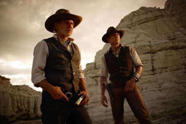 What can be said about Cowboys & Aliens? It could be an amazing exploration of American genre pictures, the clash of two of our mythological frontiers, or a dark perversion of a John Ford movie. That, or it could be the next Wild, Wild, West. The film stars two of our best action stars, Harrison Ford (the fading veteran) and Daniel Craig (arguably our most dignified leading man) and is directed by Iron Man's Jon Favreau.  Most of the movie's success will ride on Favreau, the script, and the overall tone. Chances are it's just going to be okay, but how great would it be if it turned out to be brilliant, and they had to start putting Cowboys & Aliens on college syllabi? Just a thought.Reviews have been alright, with Nick Pinkerton from The Voice saying: "Director Jon Favreau's experiment in genre crossbreedingâa Western-sci-fi mashup pumped full of inspirational all-in-this-together spiritâis a cute, crowd-pleasing idea, though more decadent than a revitalization of either genre. The sci-fi element is such standard-issue space-invader stuff as to be hardly worth consideration as anything other than a gimmick. The Western tropes are more lovingly dealt with, but here the genre, which has long striven toward maturity, is made âfunâ again through dislocation from historical fact."It should be noted that Favreau is a capable storyteller among blockbuster blowhards. As in his handling of the first Iron Man, he displays here the rare ability to patiently lay down the track along which his narrative will move, and he gets some good work from his performers."      
